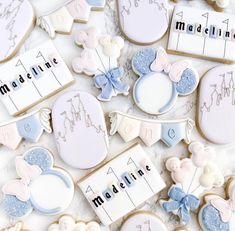 some cookies that are on top of a white table with blue and pink icing