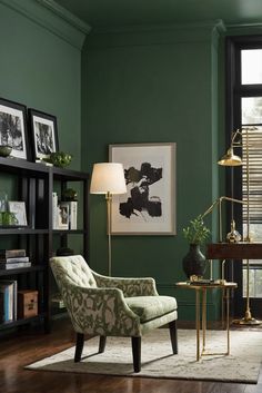 a living room with dark green walls and furniture in the corner, along with a gold lamp