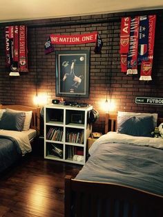 two beds in a room with flags hanging on the wall and bookshelves behind them