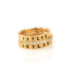 This set of Gold Stacking Rings is Gorgeous & amazing quality. It can be personalized with a name or a date on the hand stamped ring. This comes in sizes 6-9 and is sure to be your favorite in design & personal meaning! This set includes: 2-    personalized 3mm hand stamped ring- $52 1-    crystal ring- $20 Total  $72.00 If you would like to create your own stack of rings please visit my ring section and you can design your own. Just add each one to your cart individually. Link to Catchin Butter Gold Name Ring, Stackable Name Rings, Gold Stacking Rings, Mother's Ring, Stamped Ring, Hand Stamped Ring, How To Wear Rings, Mom Ring, Name Ring