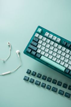 a keyboard and headphones on a blue surface with one plugged into the earphone