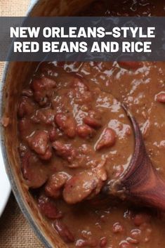 a wooden spoon stirring beans and rice in a pot with text reading new orleans style red beans and rice