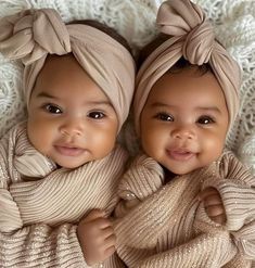 two baby girls wearing head wraps and scarves