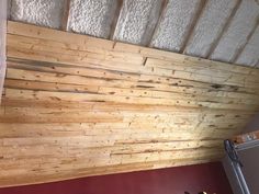 an unfinished room with wood paneling on the ceiling