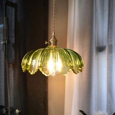 a green glass light hanging over a sink