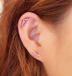 a close up of a person's ear with some piercings on it,