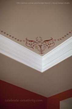 the corner of a room with a decorative crown on it's ceiling, painted in brown and white