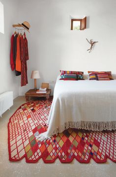 a bedroom with a bed, lamps and clothes on hangers above the headboard