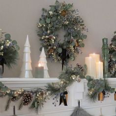 a mantle with wreaths and candles on it