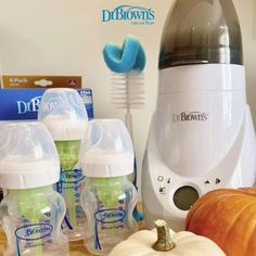 the baby bottles are sitting on the table next to the juicer and pumpkins