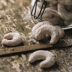 some doughnuts are sitting on a table next to a glass jar and a knife