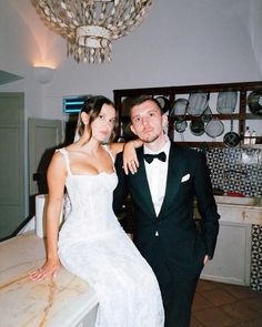 a man in a tuxedo standing next to a woman in a white dress