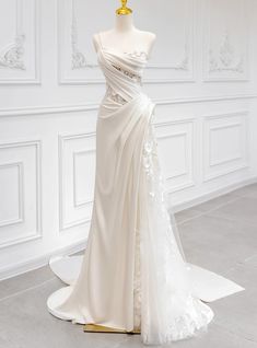 a wedding dress on display in a white room