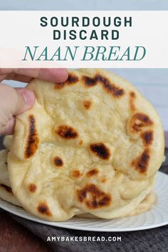 a hand holding up a homemade naan bread on a plate with the words sourdough disard