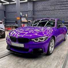 a purple car is being worked on in a factory