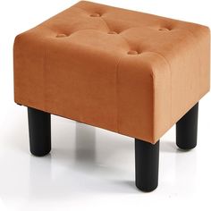 an orange ottoman sitting on top of a white floor