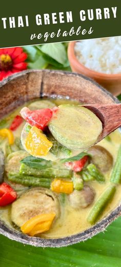 thai green curry vegetable soup in a wooden bowl with spoon and rice on the side