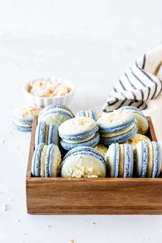 blue and white macaroni cookies in a wooden tray with striped napkins on the side