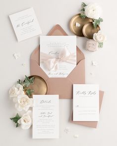 the wedding stationery is laid out on top of an envelope