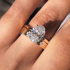 a close up of a person's hand with a diamond ring on their finger