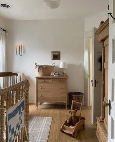 a baby's room with a crib, dresser and rocking horse in it