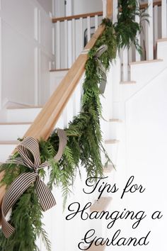 steps decorated with greenery and bows for hanging garland on the bannister railing