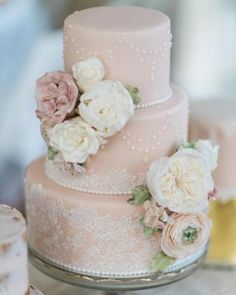 a pink wedding cake with white flowers on top