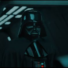 darth vader is standing in the dark room