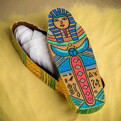 an open shoe box with yarn in it on a yellow blanket covered bedding area