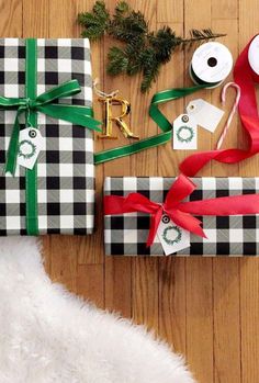 two wrapped presents are sitting on the floor next to some ribbon and other christmas decorations