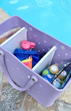 a purple container filled with items next to a swimming pool