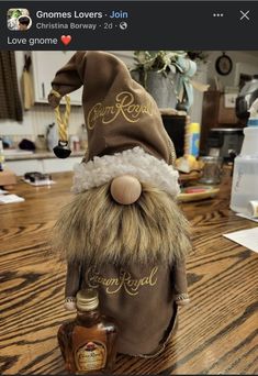 a bottle with a gnome's hat on top of it sitting on a table