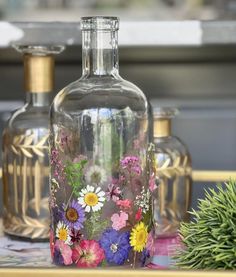 three vases with flowers painted on them are sitting on a tray next to a potted plant