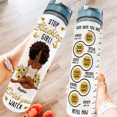 a person holding up two water bottles with stickers on them