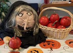 a table topped with lots of pumpkins next to a basket filled with red apples