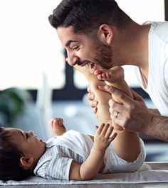 a man playing with a baby on the floor