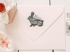 a white envelope with a rabbit stamp on it and some flowers in the corner next to it