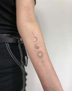 a woman's arm with a tattoo on it that has the sun and moon