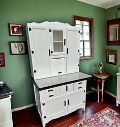 a white cabinet sitting on top of a hard wood floor