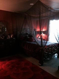 a bed room with a neatly made bed and a red rug