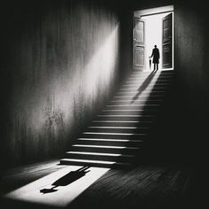 a man is walking up some stairs towards an open door with the light coming in