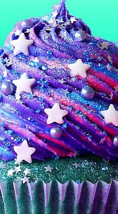 a cupcake with purple frosting and stars on top