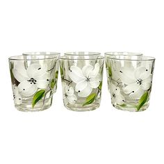 four glass cups with white flowers on them