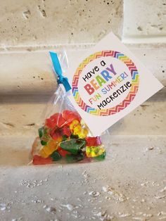 a bag filled with gummy bears sitting on top of a white counter next to a sign