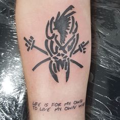 a black and white tattoo on the leg of a person's arm with words written below it