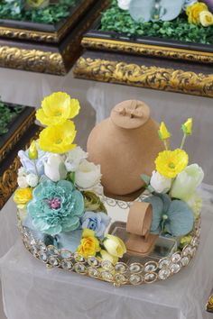 there is a cake with flowers on the top and a teapot in the middle