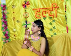 a woman in a yellow sari sitting on a couch