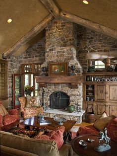 a living room filled with lots of furniture and a fire place in the middle of it