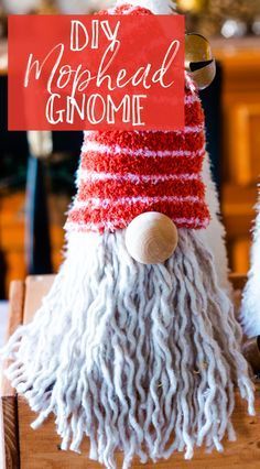 a gnome made out of yarn sitting on top of a wooden box with the words diy woolhead gnome