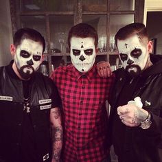 three men with painted faces posing for the camera